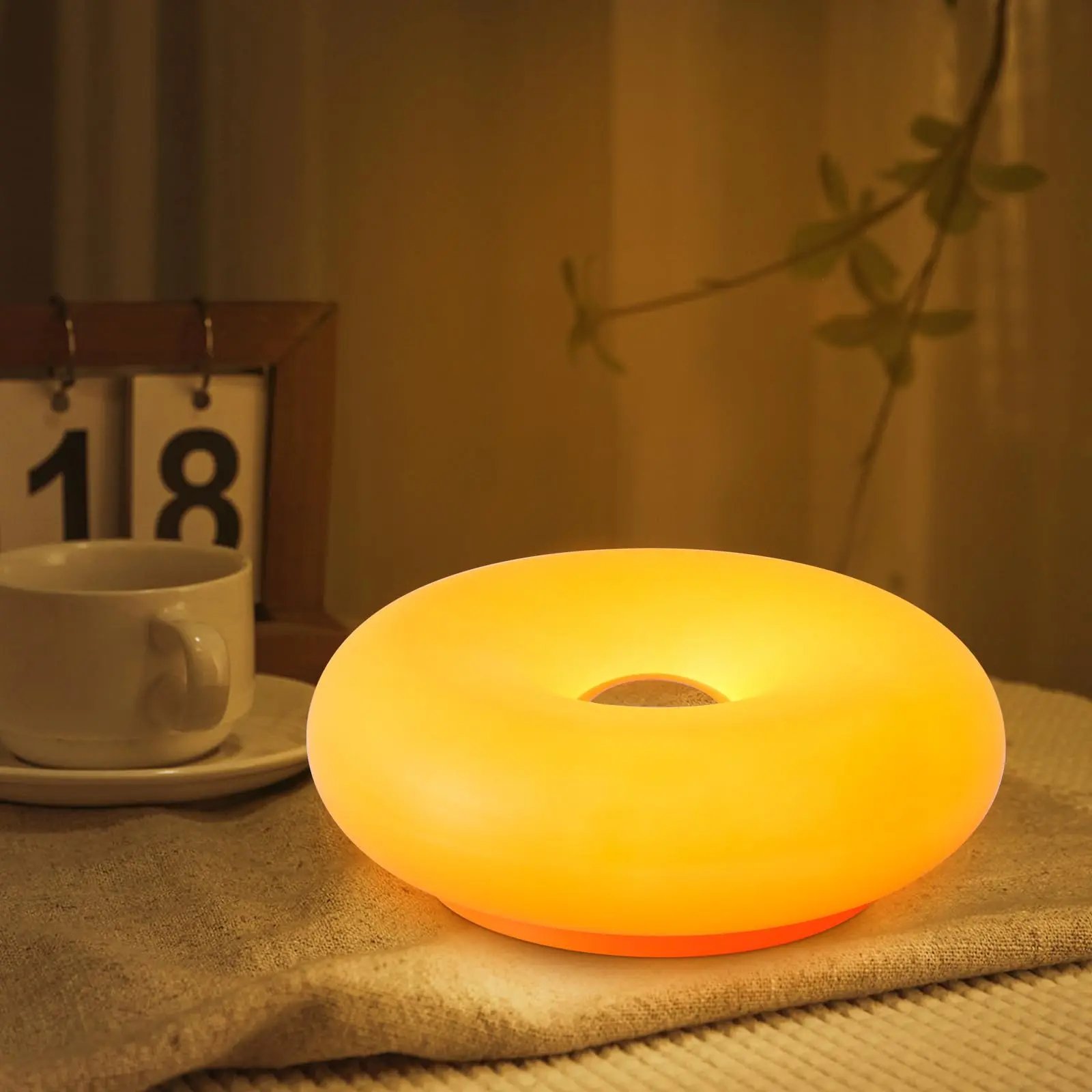 Doughnut LED night lamp glowing on a wood table