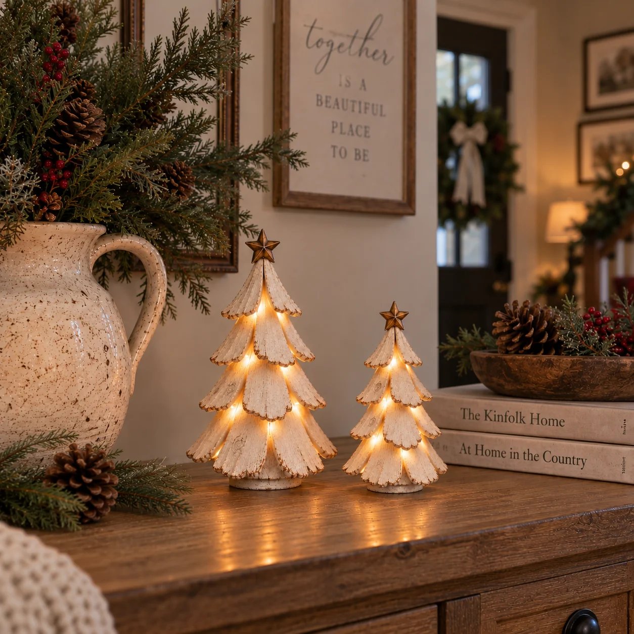 Vintage lighted Christmas tree figurines glowing on a warm farmhouse console