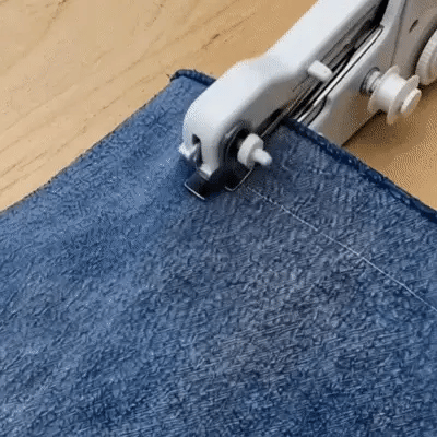 Portable handheld sewing machine making a quick fabric repair